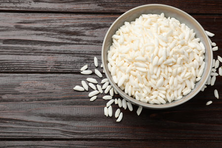 Puffed rice in bowl on wooden table, top view. Space for textの写真素材