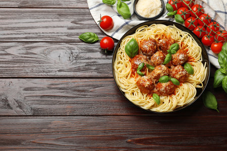 Delicious pasta with meatballs and ingredients on wooden table, flat lay. Space for textの写真素材