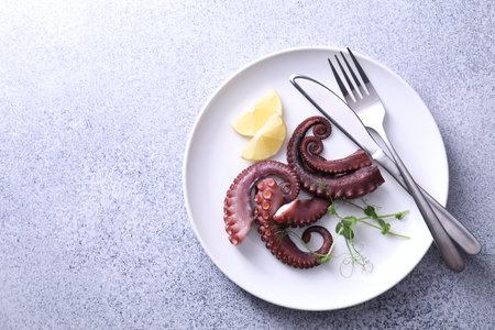 Appetizing octopus tentacles served on gray table, top view. Space for textの写真素材
