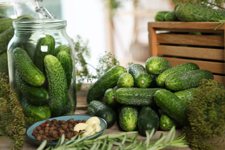 Fresh cucumbers, dill, rosemary and spices on wooden table, closeup. Preparation for picklingの写真素材