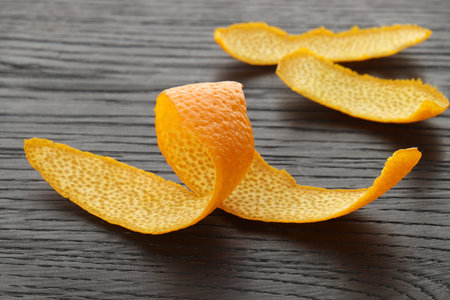 Fresh orange peels on wooden table, closeupの写真素材