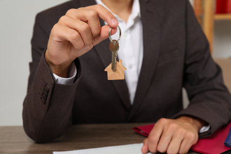 Real estate agent with house key at table, closeupの写真素材