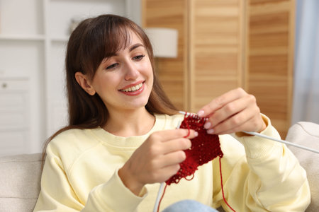 Beautiful woman knitting with needles at homeの写真素材
