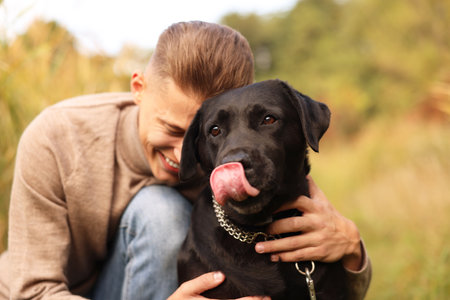 Smiling man with cute dog outdoors on autumn dayの写真素材