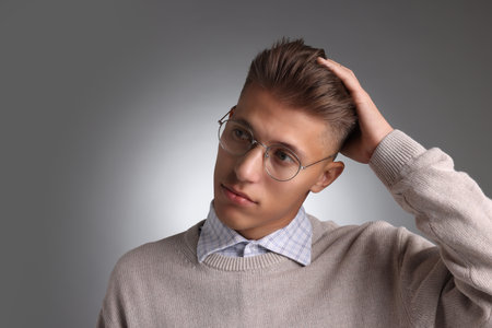 Handsome young man with stylish haircut on gray backgroundの写真素材