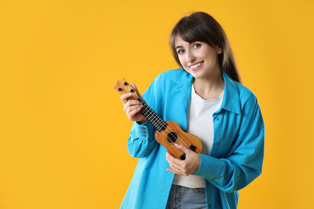 Person playing ukulele on orange background, space for text
