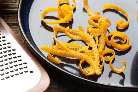 Fresh orange zest and grater on wooden table, closeupの写真素材