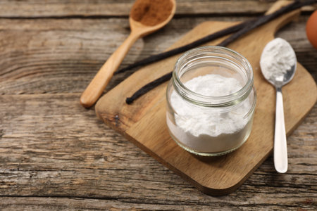 Baking powder in jar on wooden table, closeup. Space for textの写真素材