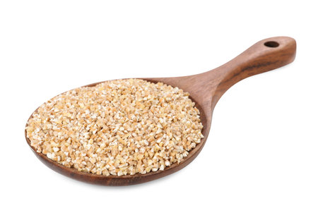 Dry wheat groats in wooden spoon isolated on whiteの写真素材