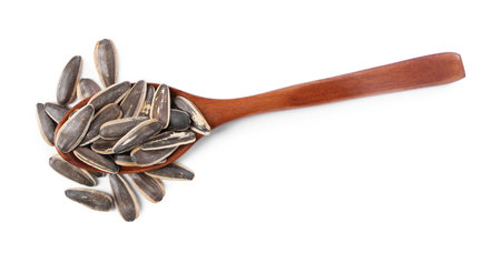 Sunflower seeds in wooden spoon isolated on white, top viewの写真素材