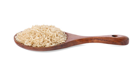 Raw rice in wooden spoon isolated on whiteの写真素材