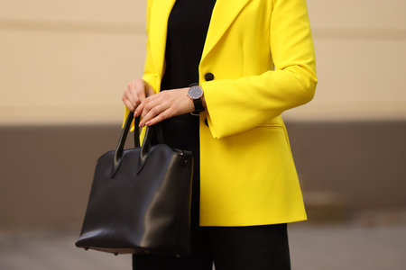 Businesswoman in stylish suit with bag outdoors, closeupの写真素材