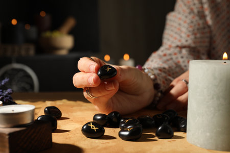 Woman with rune Gebo at table indoors, closeup