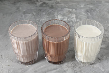 Delicious protein shakes in glasses on gray textured table, closeupの写真素材