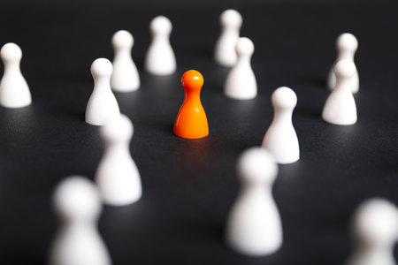 Winner concept. Orange pieces among white ones on black background, selective focusの写真素材