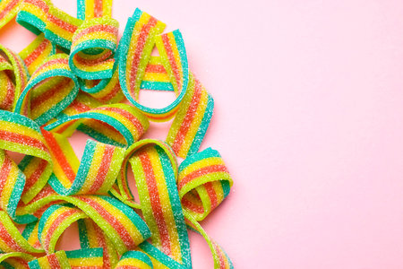 Tasty rainbow sour belts on pink background, top view. Space for textの写真素材