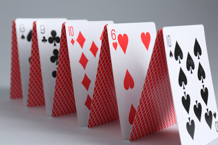 Row of playing cards on gray background, closeup