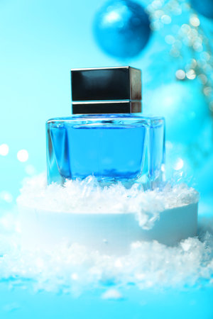 Christmas composition with perfume bottle and snow on light blue background, closeupの写真素材