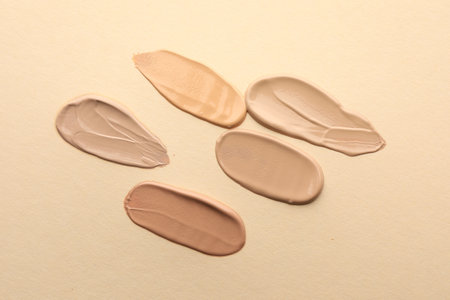 Samples of different foundations on beige background, closeupの写真素材