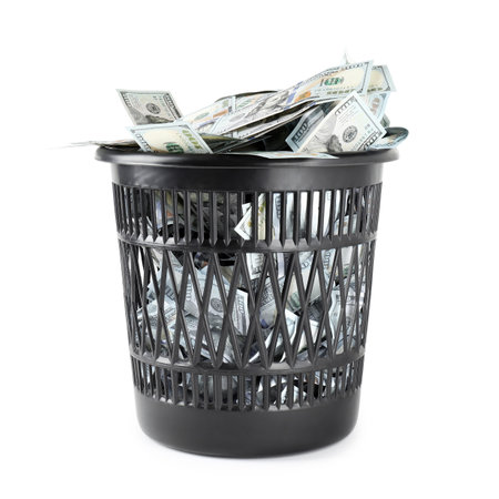 Many dollar banknotes in trash bin isolated on whiteの写真素材