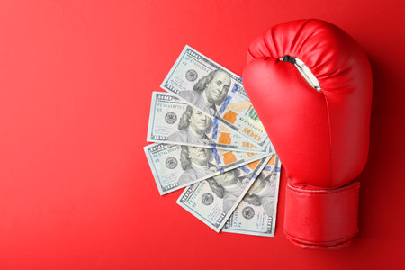 Boxing glove and money on red background, top view. Space for textの写真素材