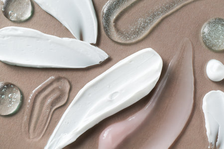 Smears of different cosmetic products on gray background, flat layの写真素材