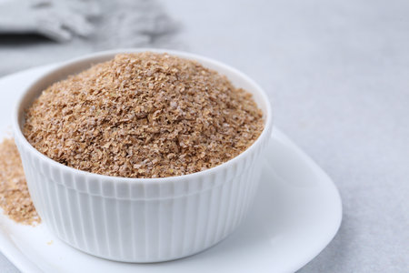 Buckwheat bran in bowl on light gray table, closeupの写真素材