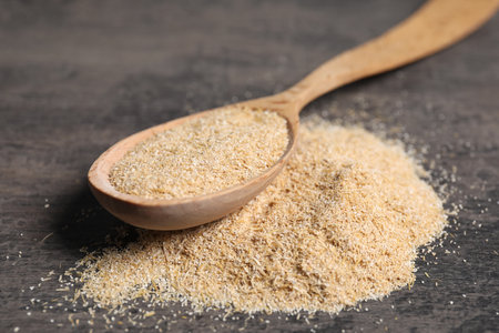 Oat bran in wooden spoon on gray table, closeupの写真素材