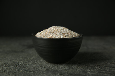 Fresh rye bran in bowl on gray textured table, closeupの写真素材