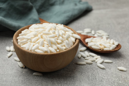 Puffed rice in bowl and spoon on light gray table, closeupの写真素材