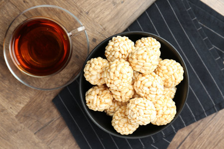 Tasty puffed rice balls and tea on wooden table, top viewの写真素材