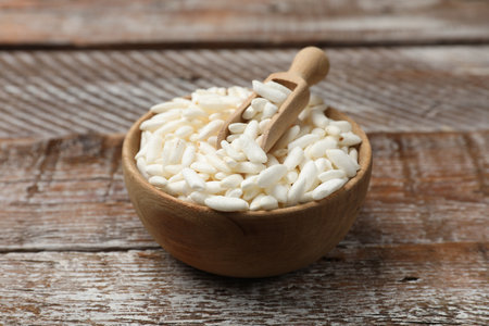 Puffed rice in bowl and scoop on wooden table, closeupの写真素材