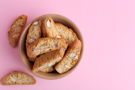 Tasty almond biscuits (Cantuccini) on pink background, flat lay. Space for textの写真素材