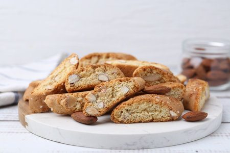 Tasty almond biscuits (Cantuccini) and nuts on white wooden table, closeupの写真素材