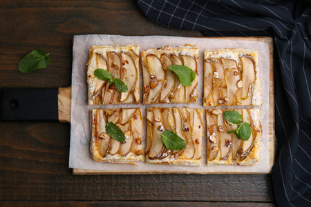 Tasty puff pastry pie with pears and mint on wooden table, top viewの写真素材