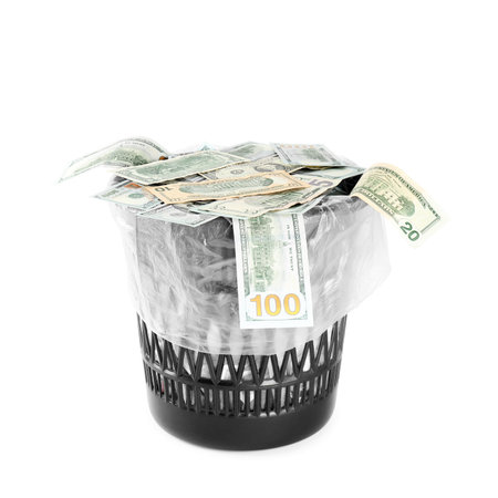 Many dollar banknotes in trash bin isolated on whiteの写真素材