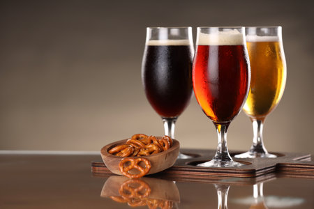Glasses with different types of beer and snacks on mirror surface.の写真素材