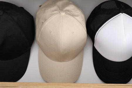 Stylish cap baseballs in chest of drawers, above view. Mockup for designの写真素材