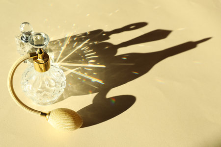 Perfume bottles casting beautiful shadows on beige background, closeup. Space for textの写真素材
