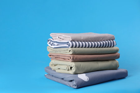 Stack of clean bed sheets on blue backgroundの写真素材