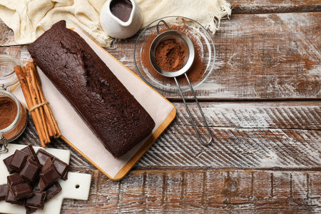 Tasty chocolate sponge cake and ingredients on wooden table, flat lay. Space for textの写真素材