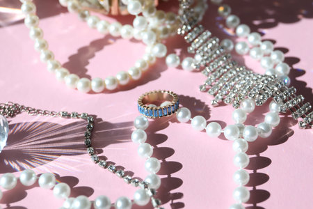 Many stylish jewelry on pink background, closeupの写真素材