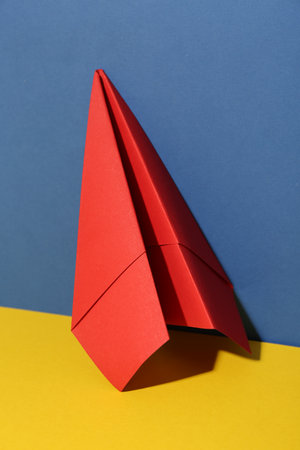 Handmade red paper plane on color backgroundの写真素材