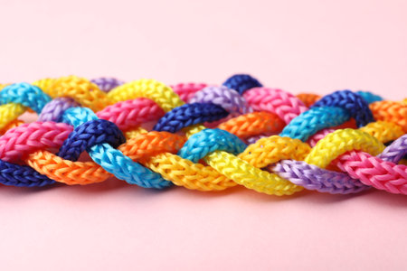 Braided colorful ropes on pink background, closeup. Unity conceptの写真素材
