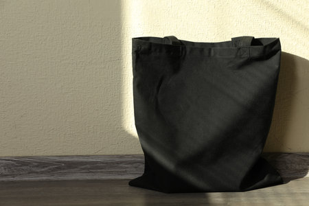 Black eco bag on floor near beige wall. Mockup for designの写真素材