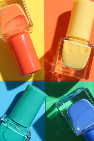 Nail polishes in bottles on color background, flat layの写真素材