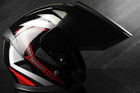 Modern motorcycle helmet with visor on dark gray background, closeupの写真素材