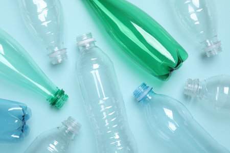 Empty plastic bottles on light blue background, flat layの写真素材