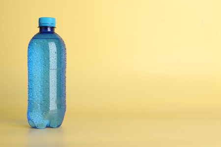 Plastic bottle of water on yellow background. Space for textの写真素材