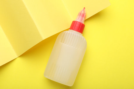 Bottle of glue on yellow background, top viewの写真素材